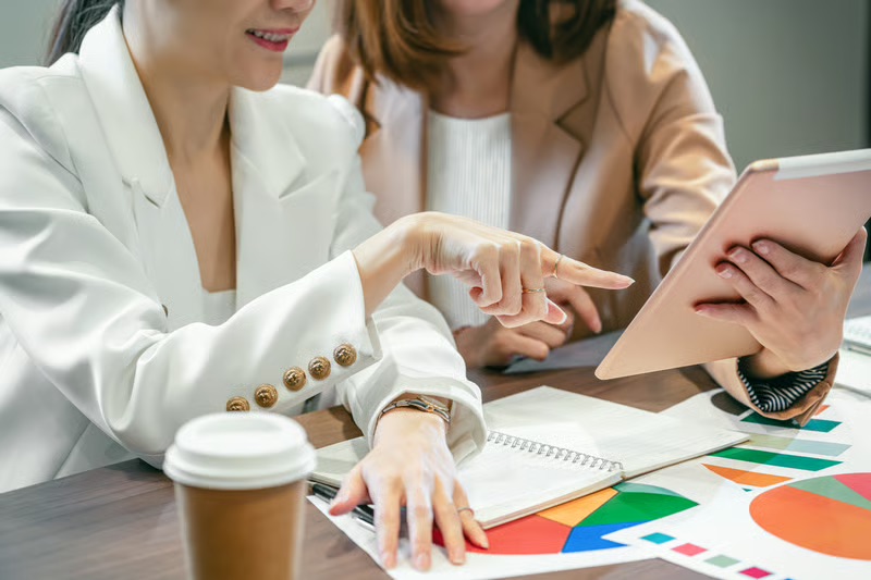 Marketing professionals reviewing digital analytics and customer data to improve AI-powered marketing and brand strategy.