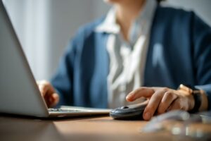 Person using a laptop and mouse while browsing online, representing internet cookies, data privacy, and online tracking.