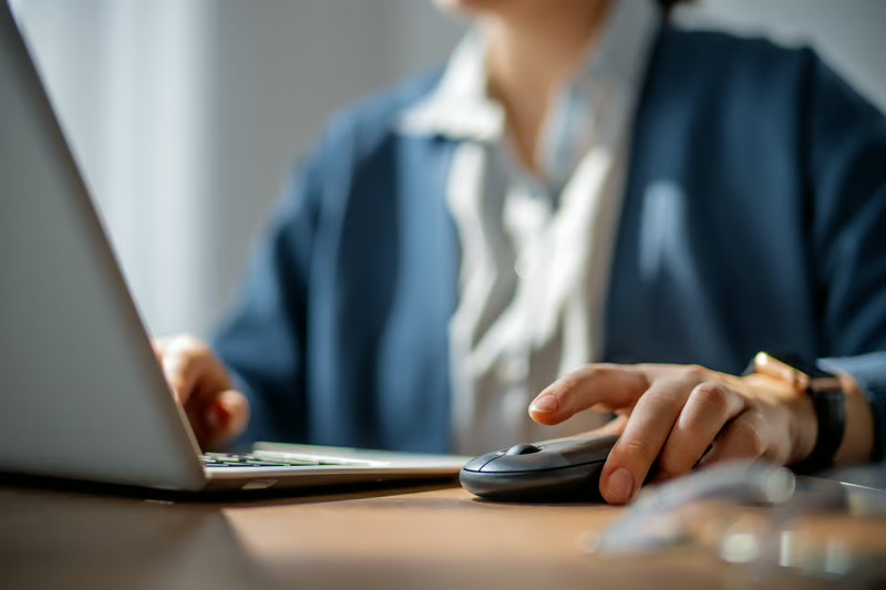 Person using a laptop and mouse while browsing online, representing internet cookies, data privacy, and online tracking.